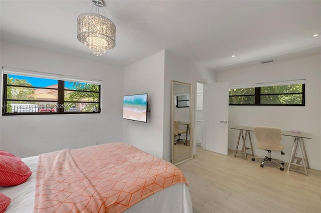 bedroom featuring multiple windows, a chandelier, and light wood-type flooring