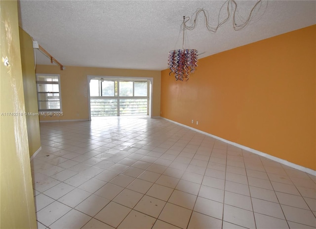 empty room featuring light tile patterned floors and a textured ceiling