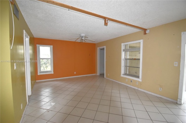 tiled empty room with a textured ceiling and ceiling fan