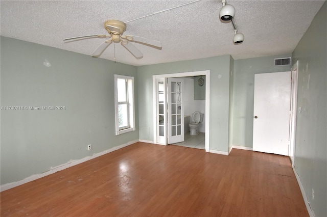 unfurnished room with hardwood / wood-style flooring, ceiling fan, and a textured ceiling