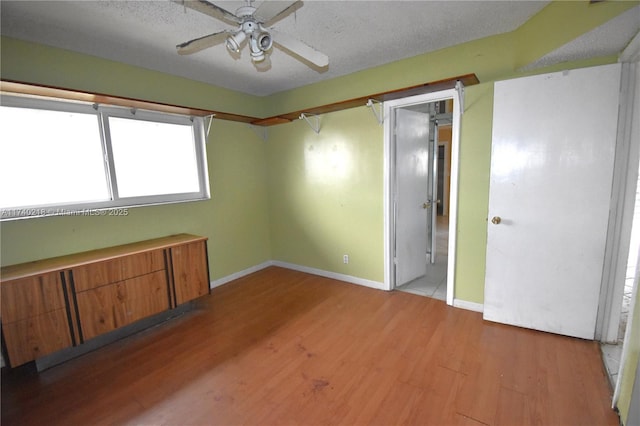 unfurnished room featuring a textured ceiling, light hardwood / wood-style flooring, and ceiling fan