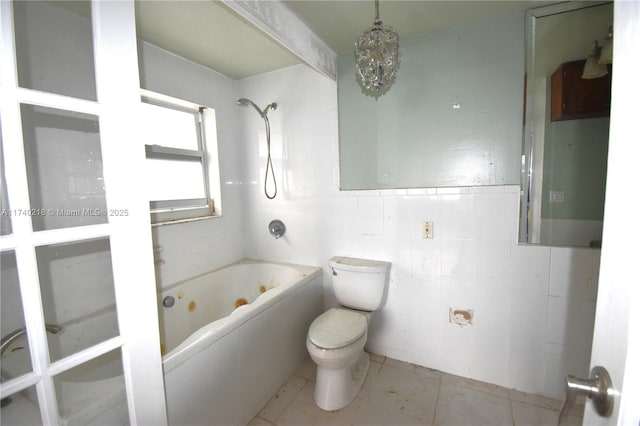 bathroom featuring tile walls, tile patterned flooring, toilet, and washtub / shower combination