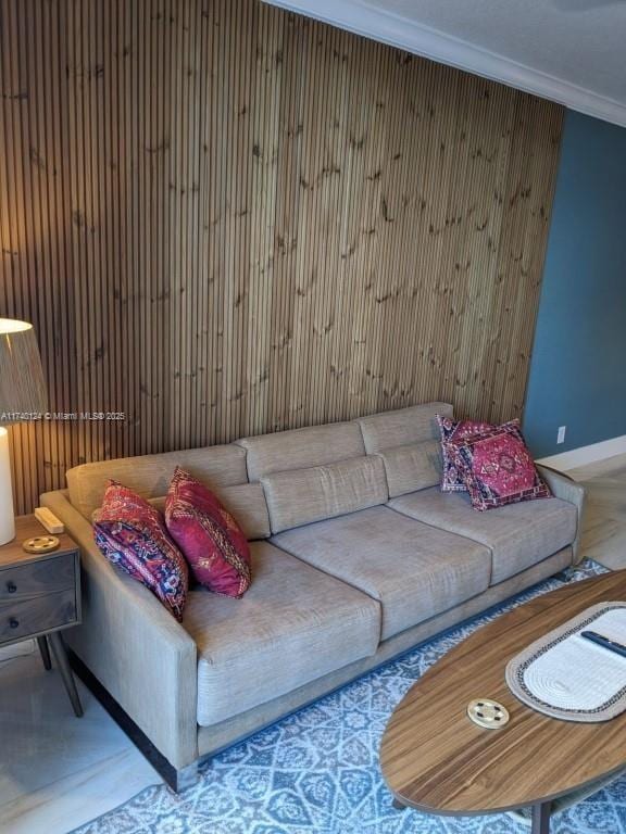 living room featuring ornamental molding and wood walls