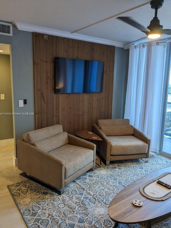 living room featuring crown molding, wood-type flooring, and ceiling fan