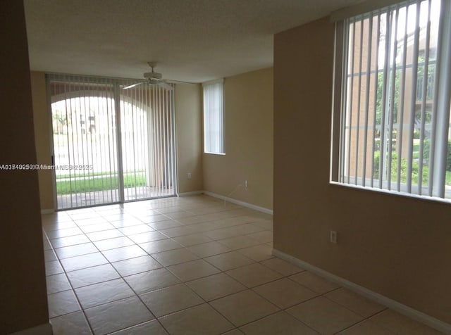 tiled empty room featuring ceiling fan