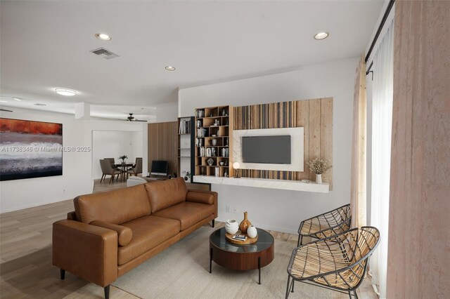 living room featuring hardwood / wood-style floors and ceiling fan