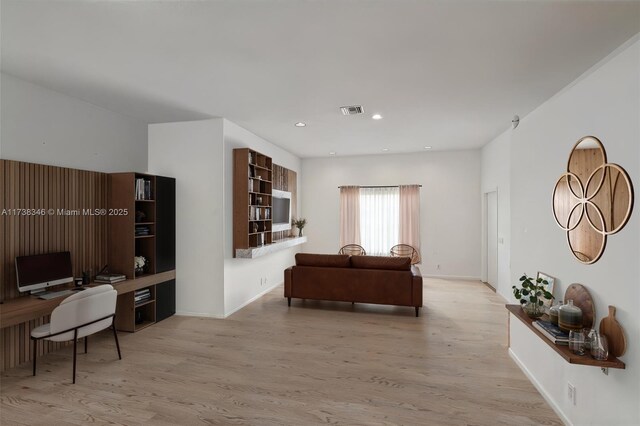 living room with built in desk and light hardwood / wood-style floors