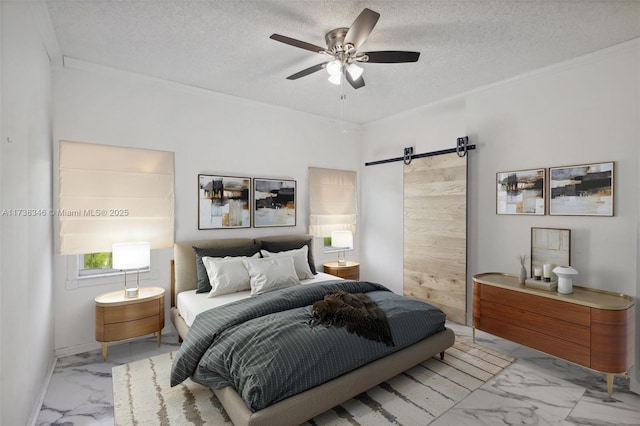 bedroom with ceiling fan, a barn door, and a textured ceiling