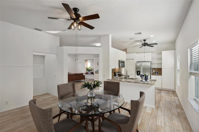 dining space featuring ceiling fan and light wood-type flooring