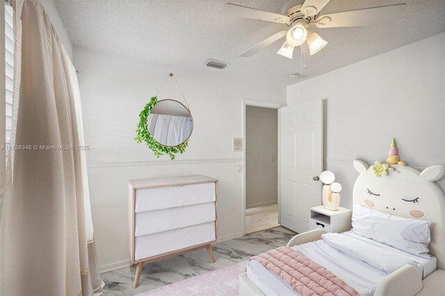 bedroom featuring ceiling fan and a textured ceiling