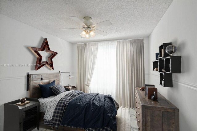 bedroom featuring ceiling fan and a textured ceiling