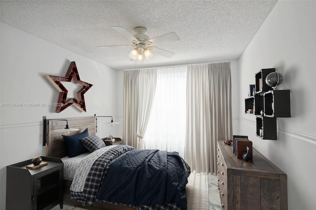 bedroom with ceiling fan and a textured ceiling