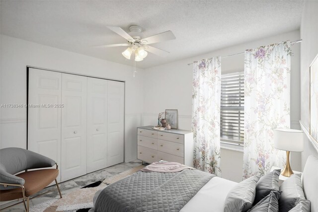 bedroom featuring ceiling fan, a closet, and a textured ceiling