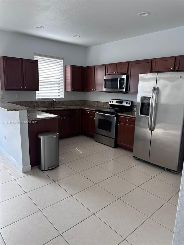 kitchen featuring light tile patterned floors, sink, a textured ceiling, and appliances with stainless steel finishes