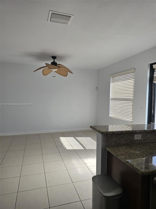 interior space featuring light tile patterned flooring and ceiling fan