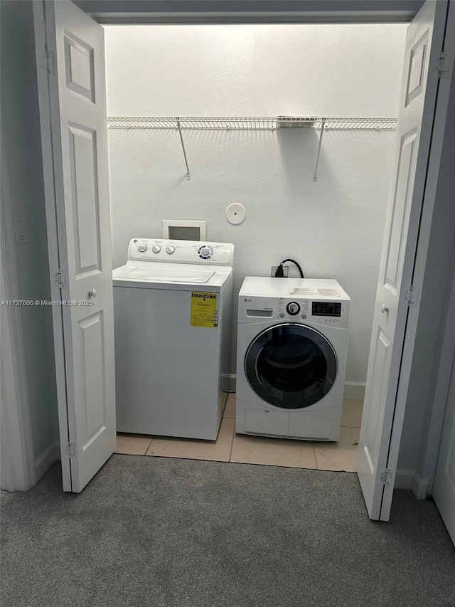 washroom with washing machine and dryer and light tile patterned floors