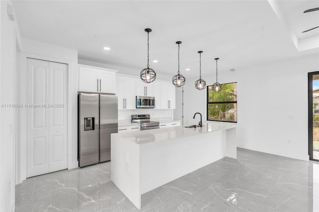 kitchen featuring white cabinetry, sink, stainless steel appliances, and an island with sink