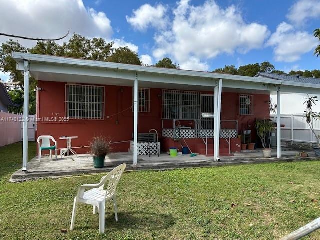 back of house featuring a yard and a patio area