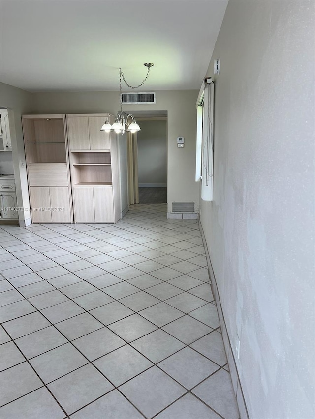 unfurnished dining area with light tile patterned flooring and a chandelier