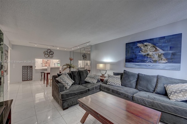 tiled living room featuring rail lighting and a textured ceiling