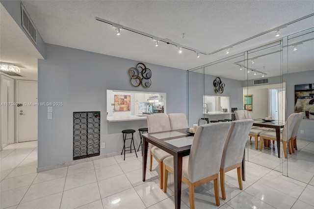 tiled dining room with a textured ceiling