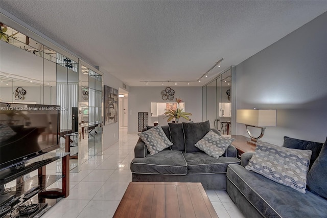 tiled living room featuring track lighting and a textured ceiling