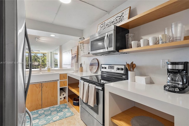 kitchen with light tile patterned floors, stainless steel appliances, light countertops, open shelves, and a sink