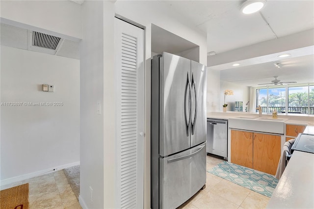 kitchen with stainless steel appliances, light countertops, visible vents, a ceiling fan, and a sink