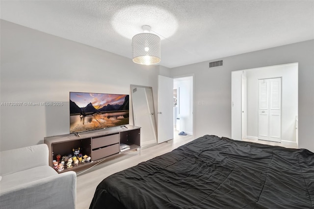 bedroom with a textured ceiling and visible vents