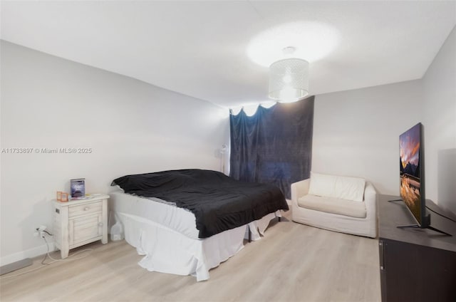 bedroom featuring wood finished floors and baseboards