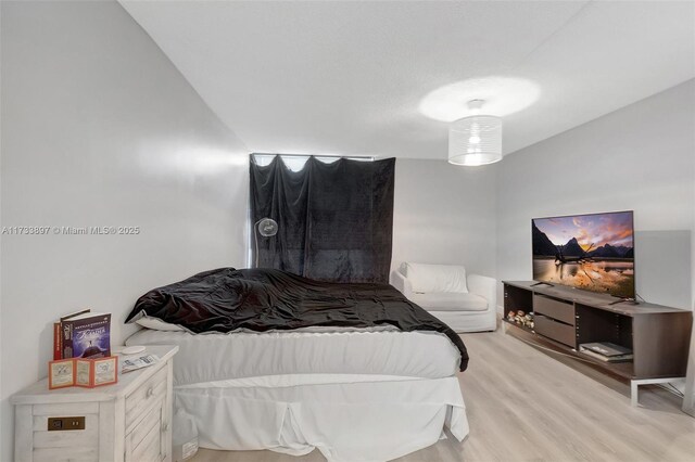 living room with ceiling fan, a textured ceiling, and light wood-type flooring