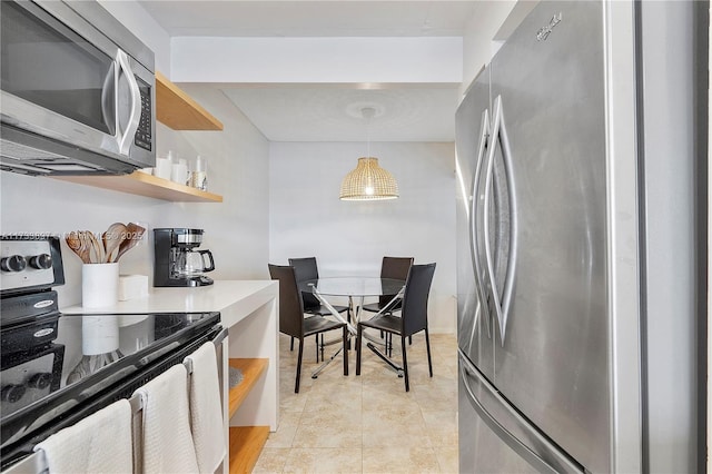 kitchen with pendant lighting, appliances with stainless steel finishes, and light tile patterned flooring