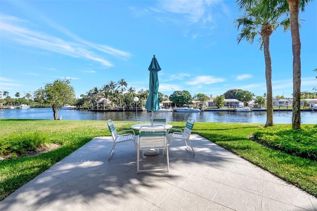 view of community featuring a patio area, a water view, and a lawn