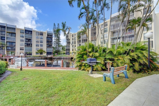 view of home's community with a water view and a yard