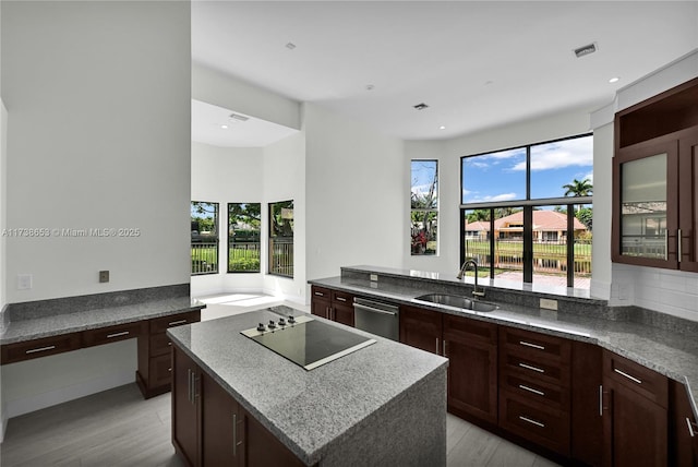 kitchen featuring sink, dishwasher, a center island, black electric stovetop, and kitchen peninsula