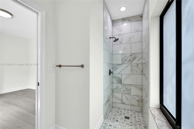 bathroom featuring a tile shower and hardwood / wood-style flooring