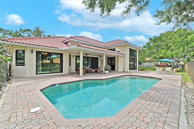 back of house featuring a fenced in pool, ceiling fan, and a patio area