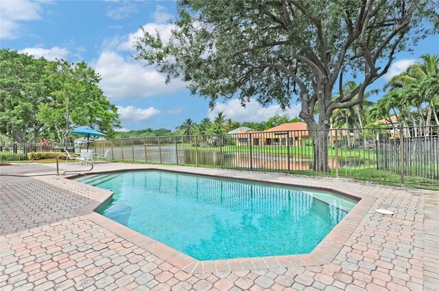 view of pool with a water view and a patio area