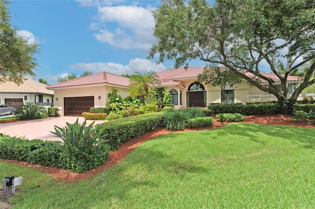 mediterranean / spanish house with a garage and a front lawn