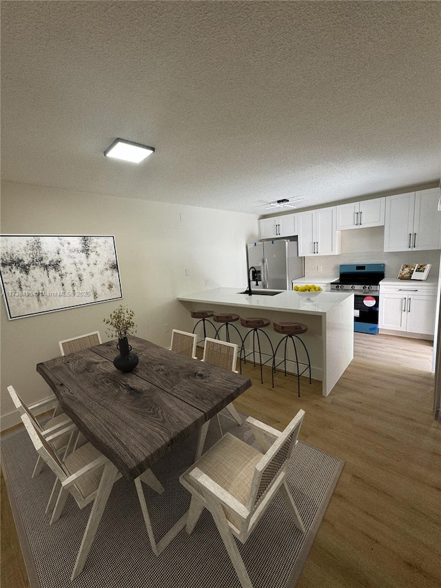 dining space featuring a textured ceiling and light wood-type flooring