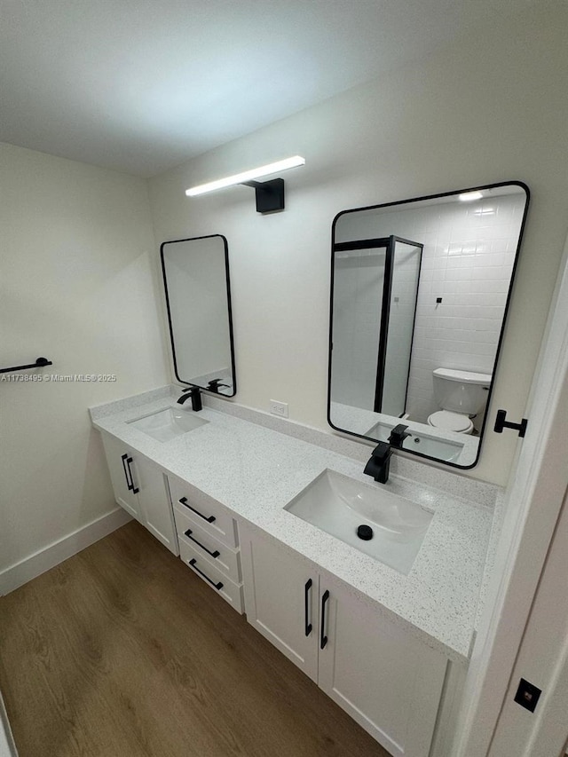 bathroom featuring vanity, wood-type flooring, and toilet