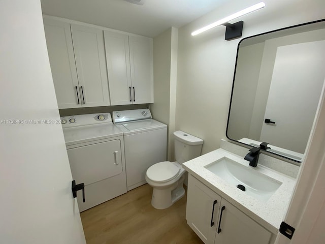 bathroom featuring vanity, washer and clothes dryer, toilet, and wood-type flooring