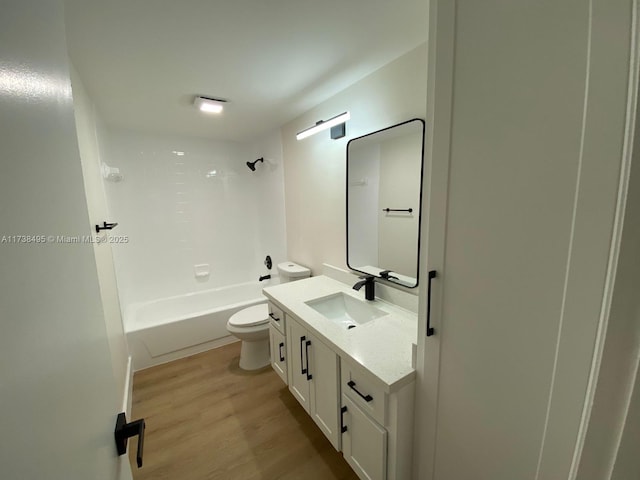 full bathroom featuring wood-type flooring, tub / shower combination, vanity, and toilet