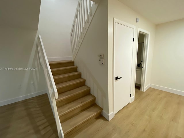 staircase with hardwood / wood-style flooring