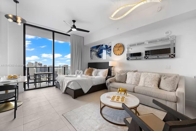 bedroom featuring access to exterior, light tile patterned floors, a wall of windows, and ceiling fan