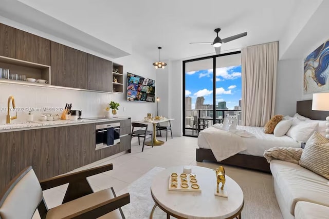 bedroom featuring expansive windows, light tile patterned floors, sink, and access to outside