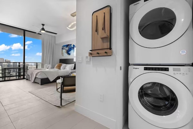 laundry room with stacked washer / dryer, light wood-type flooring, and ceiling fan