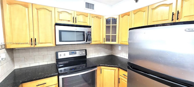 kitchen with appliances with stainless steel finishes and backsplash