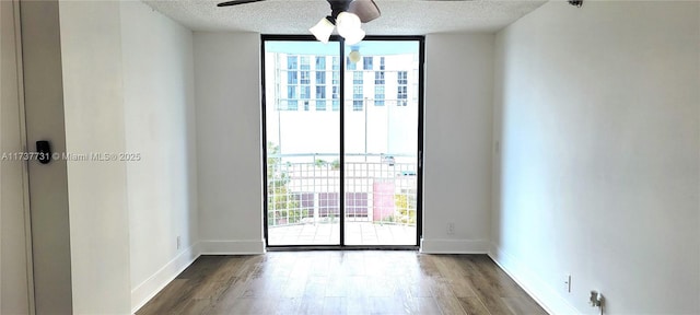 unfurnished room with hardwood / wood-style flooring, plenty of natural light, expansive windows, and a textured ceiling