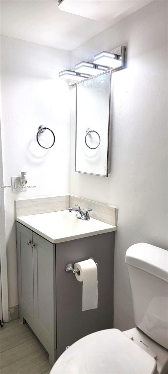 bathroom with vanity, wood-type flooring, and toilet